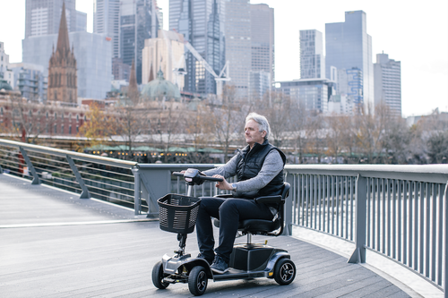 an old man happily riding a mobility scooter